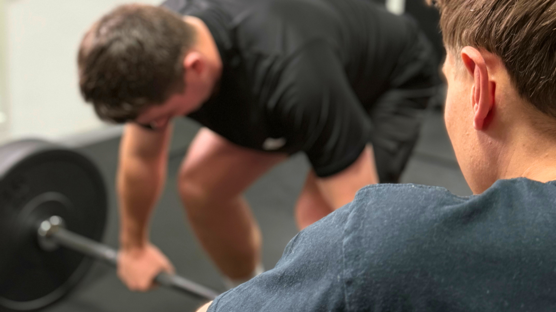 Trening siłowy ze sztangą pod okiem trenera personalnego